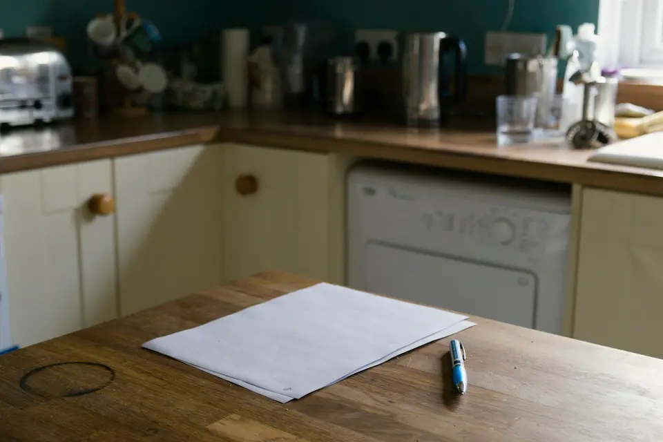 Een vel papier en een pen op een houten aanrecht in een keuken